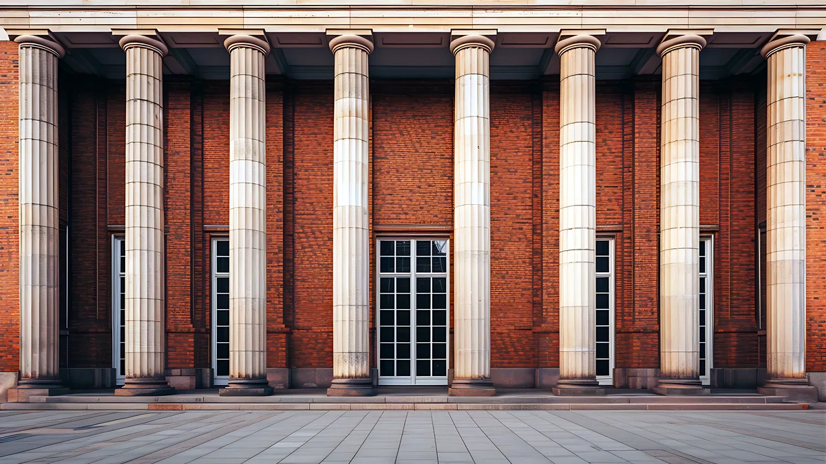 A brick bank facade with tall stone pillars and a wide set of front steps.